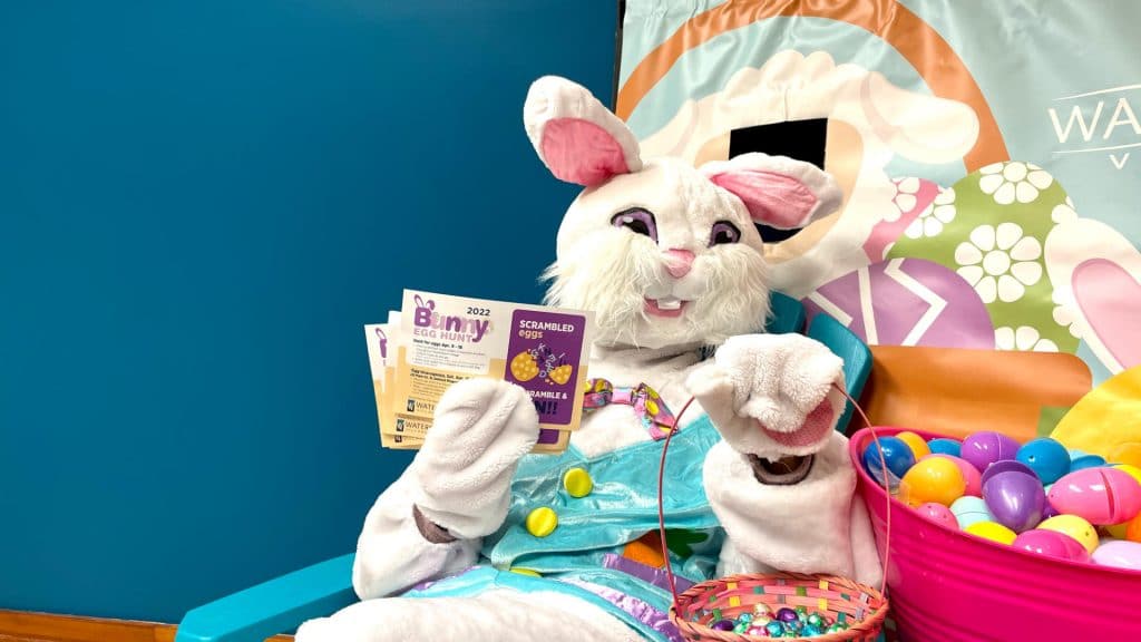 Easter Bunny sitting in a Muskoka chair holding a basket of eggs and contest ballots